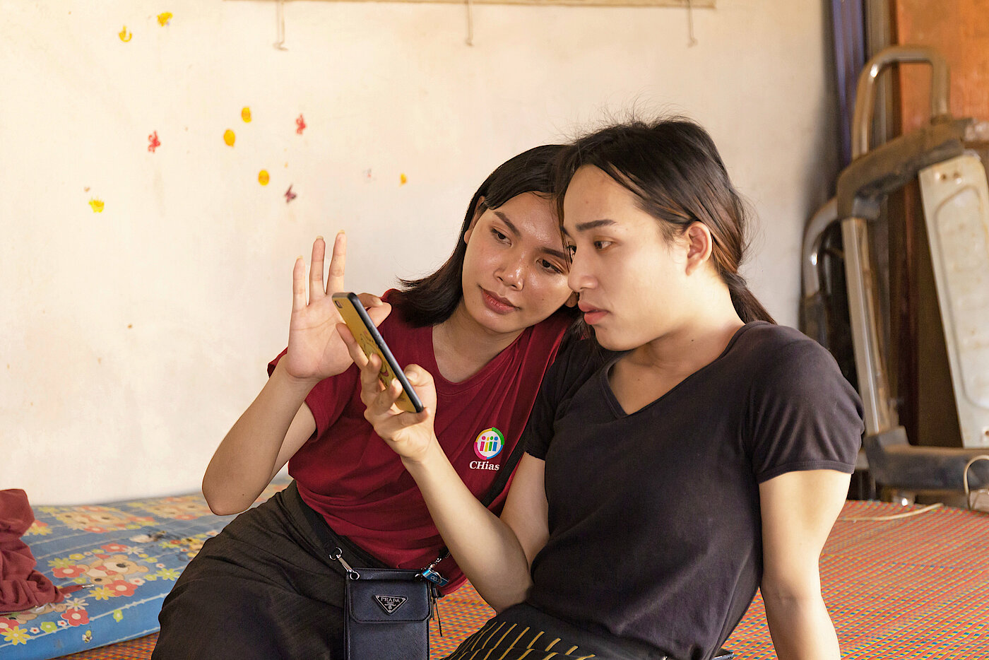 Foto: Zwei junge Frauen schauen zusammen auf ein Smartphone.