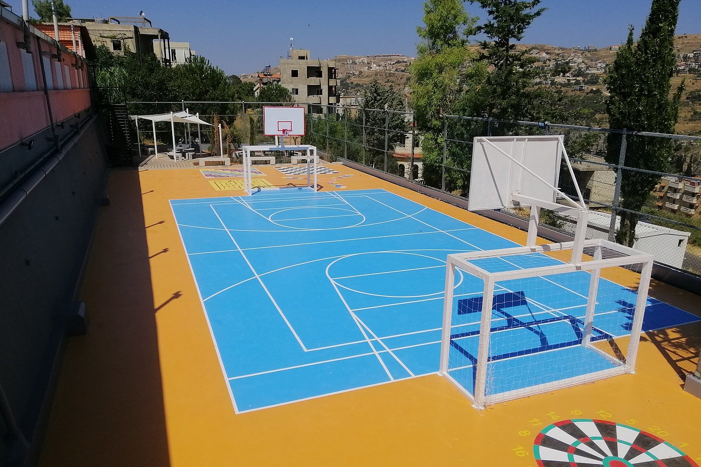 Foto: Sportspielflächen, unter anderem mit einem Spielfeld, Fußballtoren und Basketballkörben.