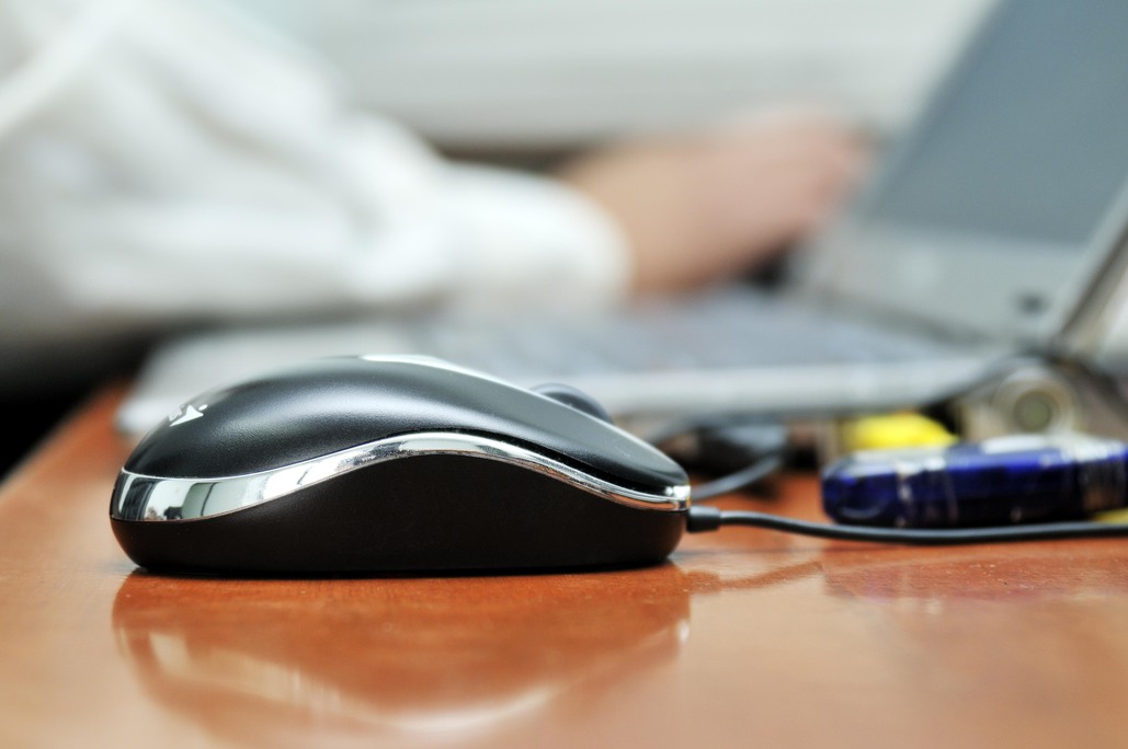Foto: Eine Computermaus auf einem Schreibtisch in Nahaufnahme.