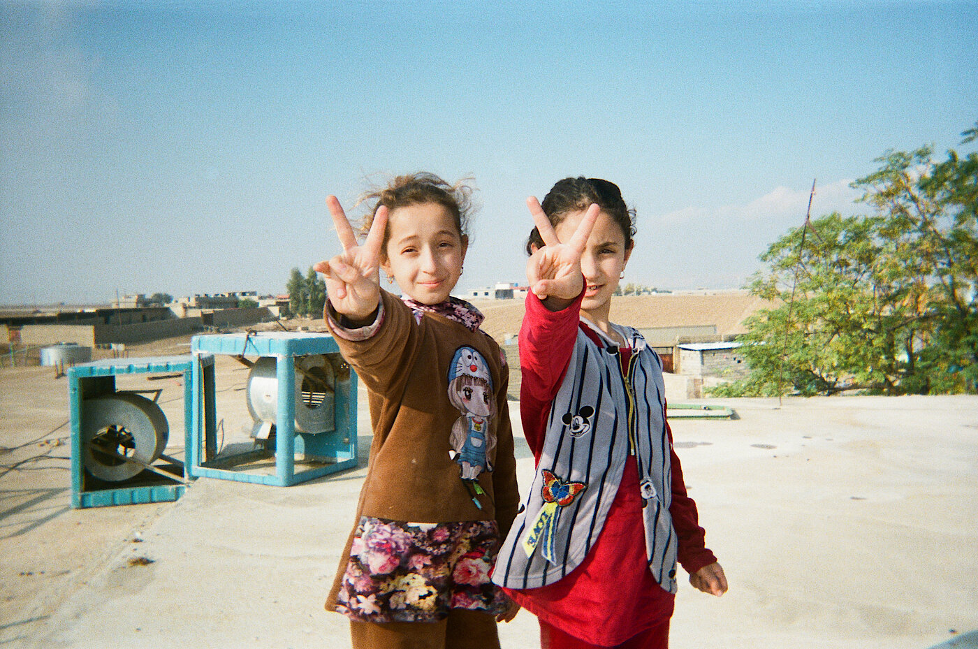 Foto: Zwei Mädchen machen mit ihren Händen das Peace- oder Victory-Zeichen.