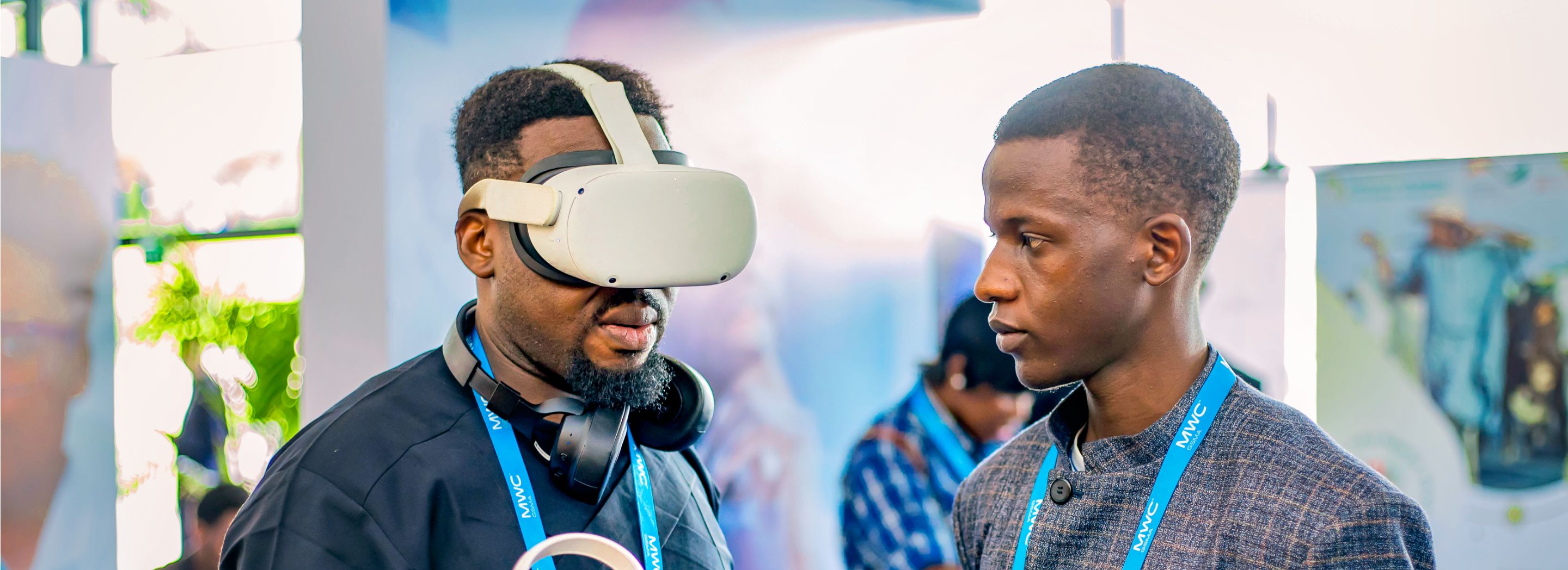 Foto: Zwei Männer stehen sich gegenüber. Der Mann links trägt eine VR-Brille.