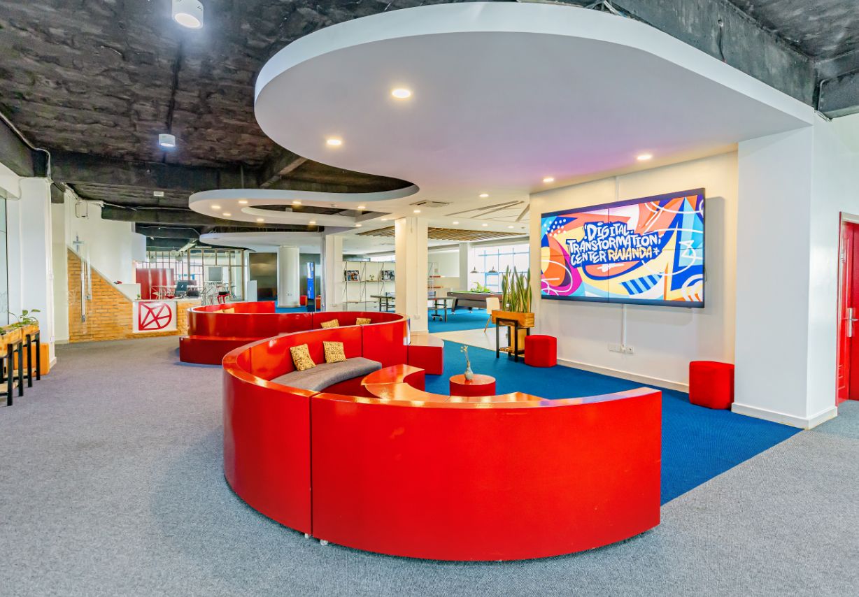 Foto: Futuristisch anmutendes Büro mit runden roten Sitzecken und einem großen Bildschirm.